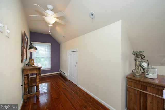a view of a livingroom with wooden floor and a ceiling fan