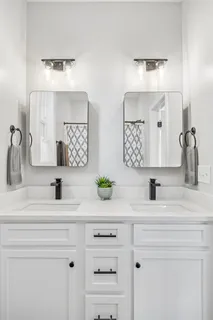 a bathroom with double vanity sink and a mirror