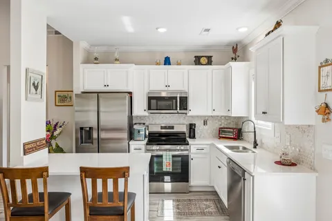 a kitchen with stainless steel appliances a refrigerator sink and cabinets