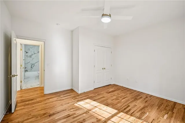 an empty room with wooden floor & closet area