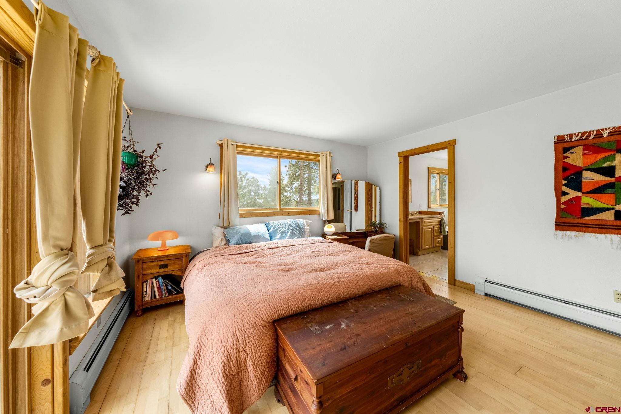 151 Sunny Lane Durango, CO 81301 - Photo 19 of 35 a bedroom with a bed and wooden floor