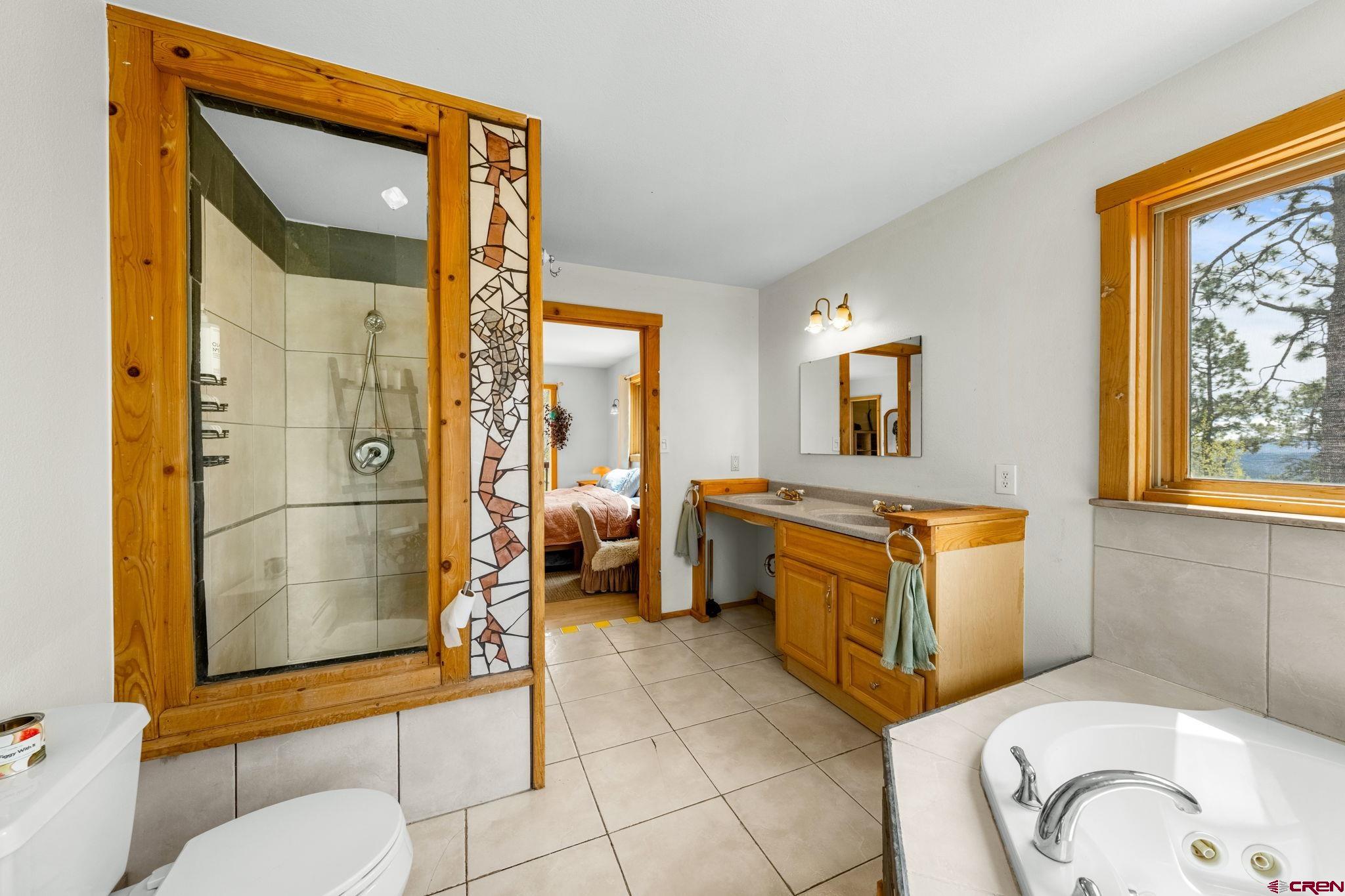 151 Sunny Lane Durango, CO 81301 - Photo 22 of 35 a bathroom with a granite countertop sink mirror vanity and toilet
