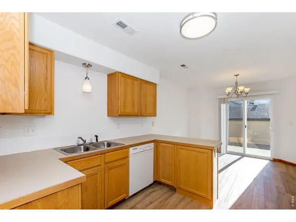a kitchen with granite countertop a sink cabinets and stainless steel appliances