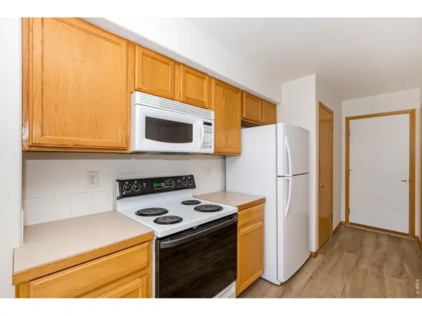 a kitchen with a refrigerator a stove top oven a sink and cabinets