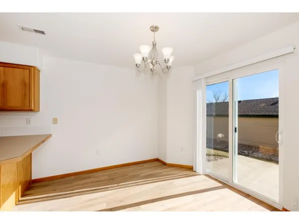 a view of a room with wooden floor and chandelier