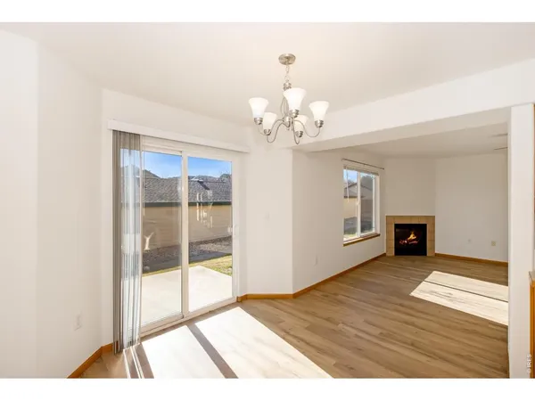 a view of a livingroom with wooden floor and a fireplace