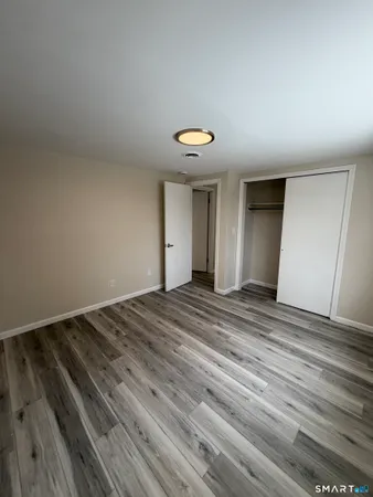 a view of a room with wooden floor and ceiling fan