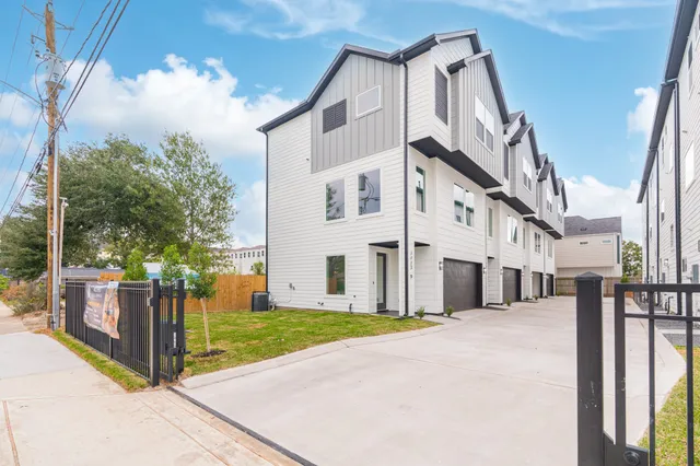 a view of a white building among the street with palm trees
