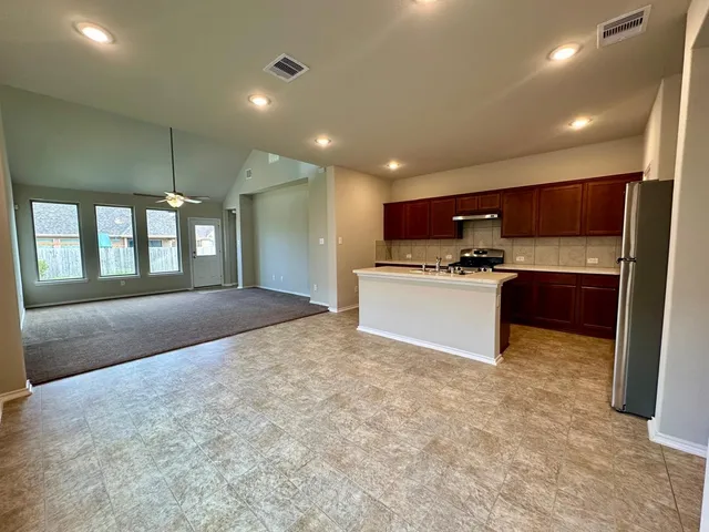 a large kitchen with kitchen island a sink stainless steel appliances and cabinets