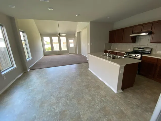 a kitchen with stainless steel appliances granite countertop a stove a sink and a refrigerator