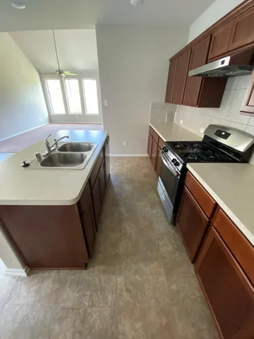 a kitchen with stainless steel appliances granite countertop a sink and a stove