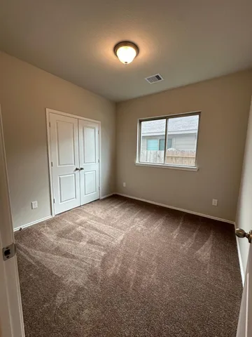 an empty room with windows and closet