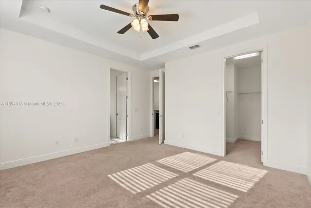 a view of a livingroom with a ceiling fan and wooden floor