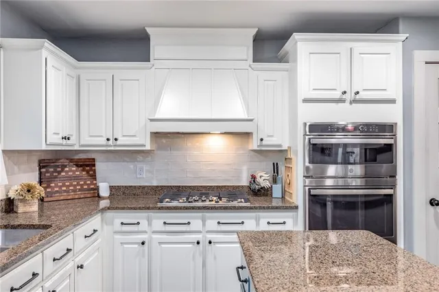 a kitchen with granite countertop a stove and cabinets