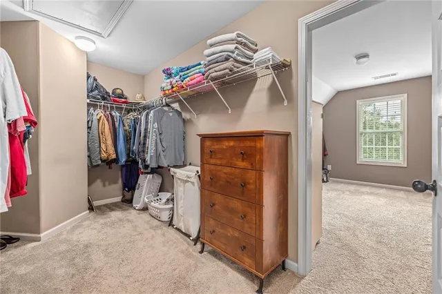a view of walk in closet with clothes and shoes