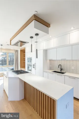 a kitchen with granite countertop a sink a stove and cabinets