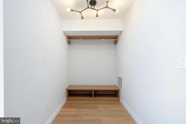 a view of a hallway with wooden floor and stairs