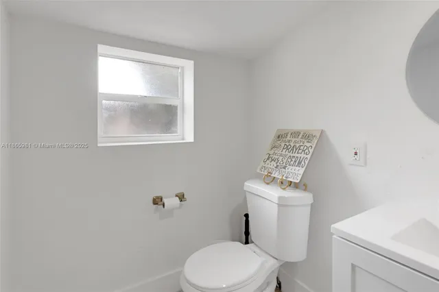 a white toilet sitting next to a bathroom sink