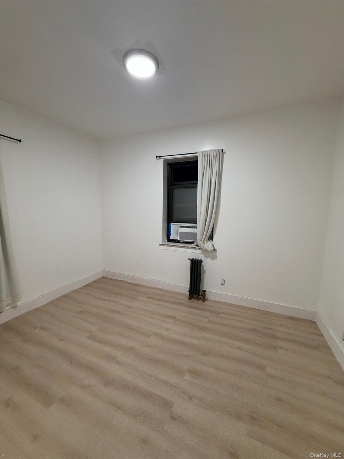 110 Stonelea Place, Unit 4A New Rochelle, NY 10801 - Photo 2 of 8 a view of empty room with wooden floor and fan