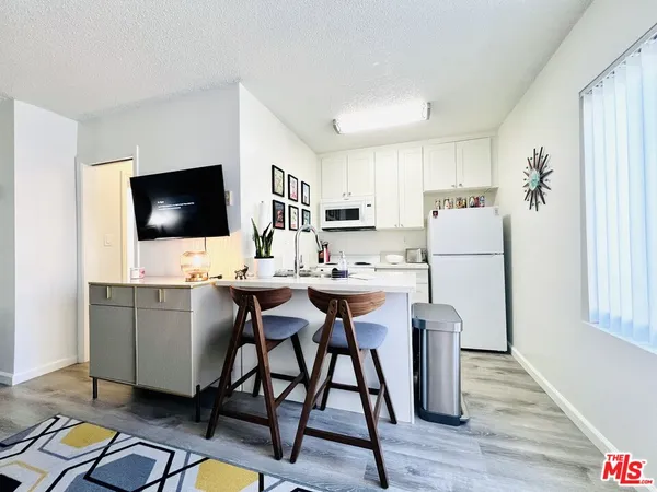 a kitchen with a table chairs refrigerator and a microwave