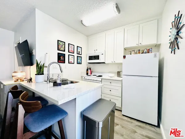 a view of kitchen with cabinets stainless steel appliances and wooden floor