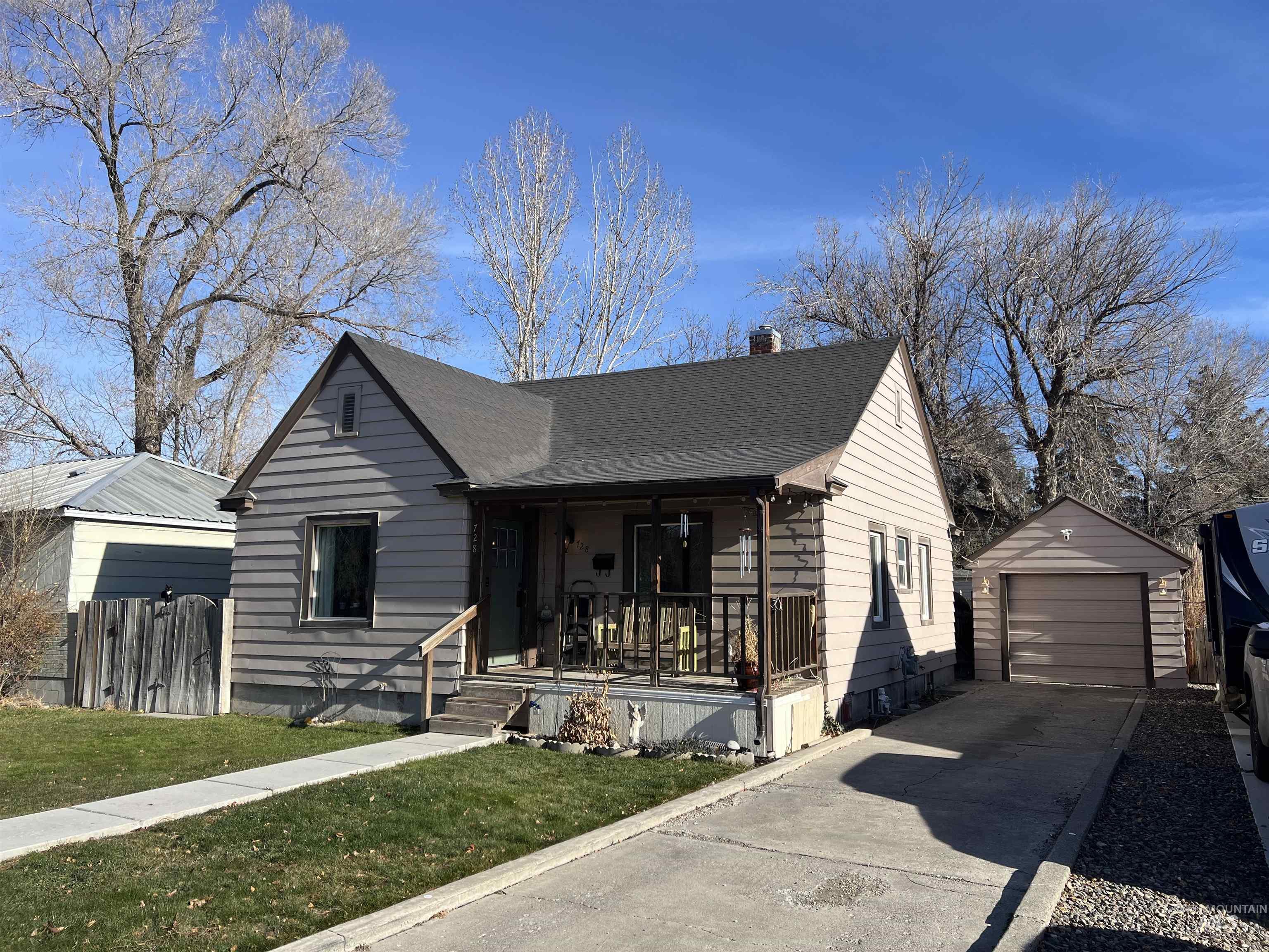 728 Locust Street Twin Falls, ID 83301 - Photo 2 of 2 Bungalow with a porch, an outdoor structure, a chimney, concrete driveway, and a garage