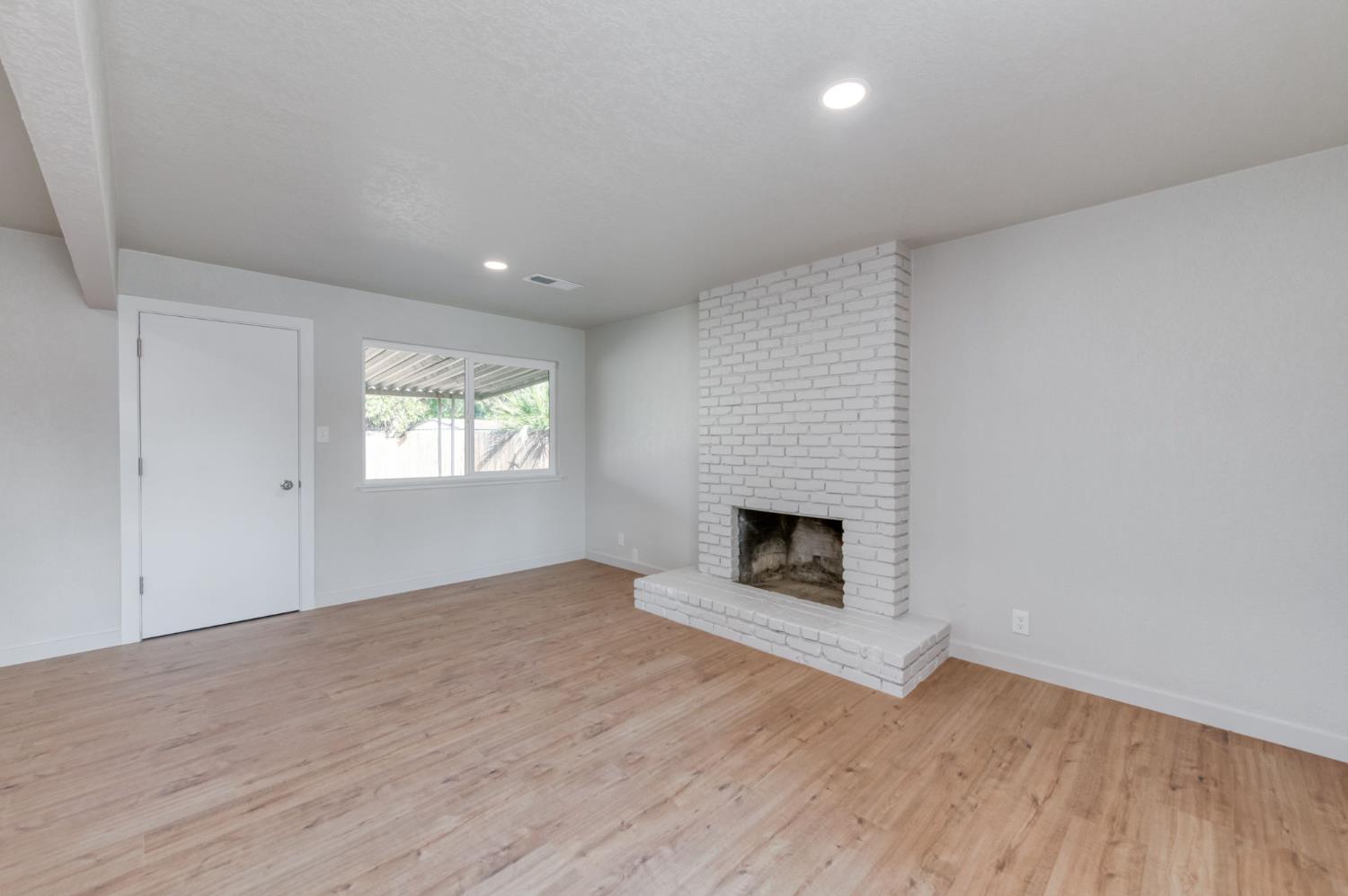 4031 East Pontiac Way Fresno, CA 93726 - Photo 11 of 46 an empty room with windows and fireplace