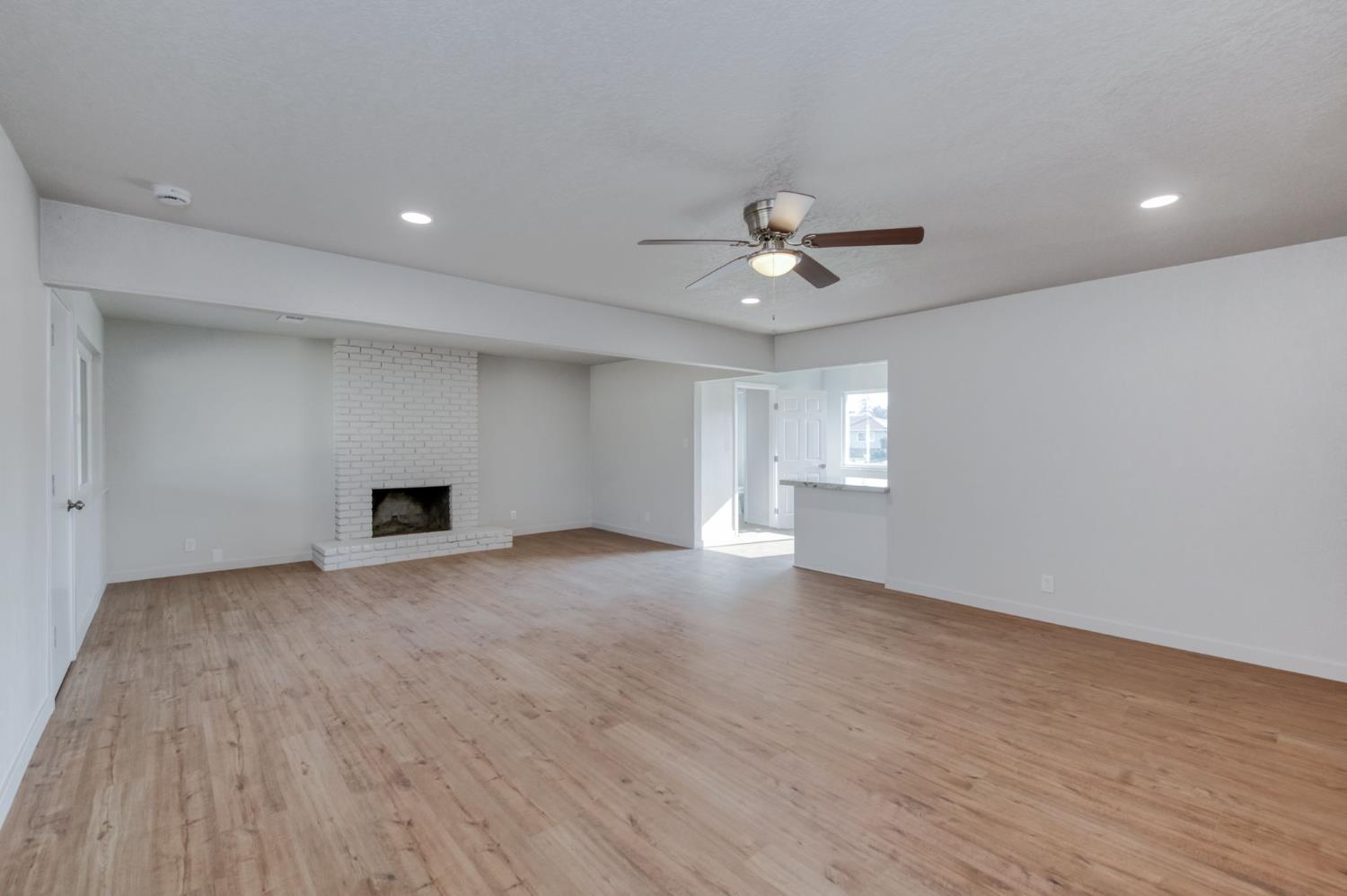 4031 East Pontiac Way Fresno, CA 93726 - Photo 13 of 46 a view of an empty room with window and wooden floor