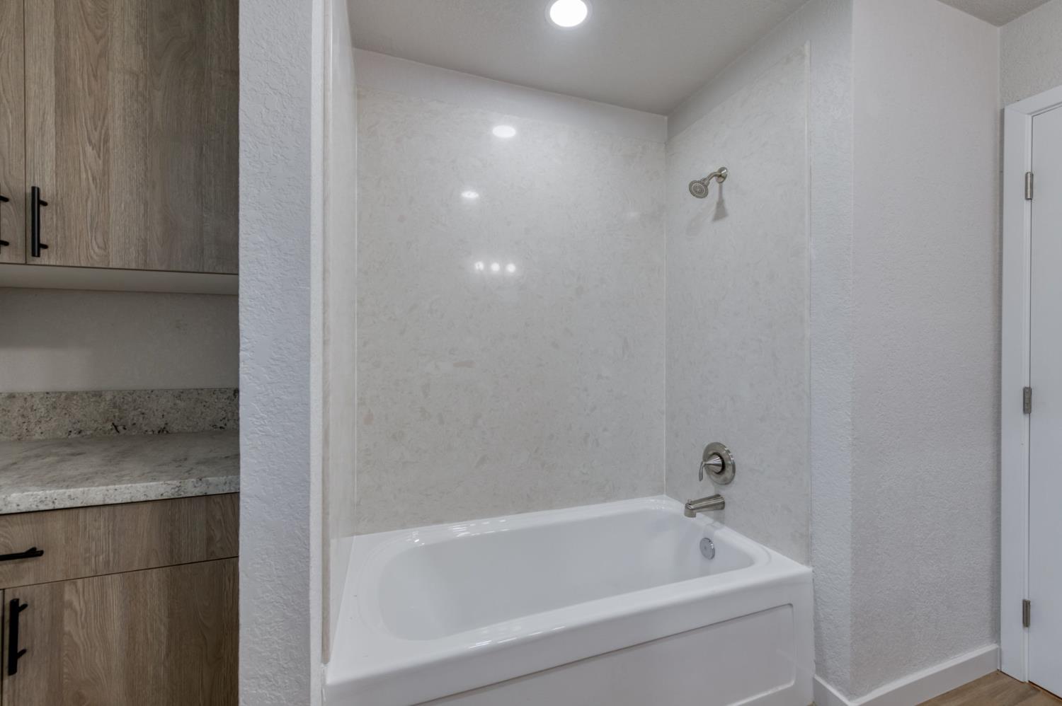 4031 East Pontiac Way Fresno, CA 93726 - Photo 21 of 46 a white bath tub sitting next to a white sink and vanity