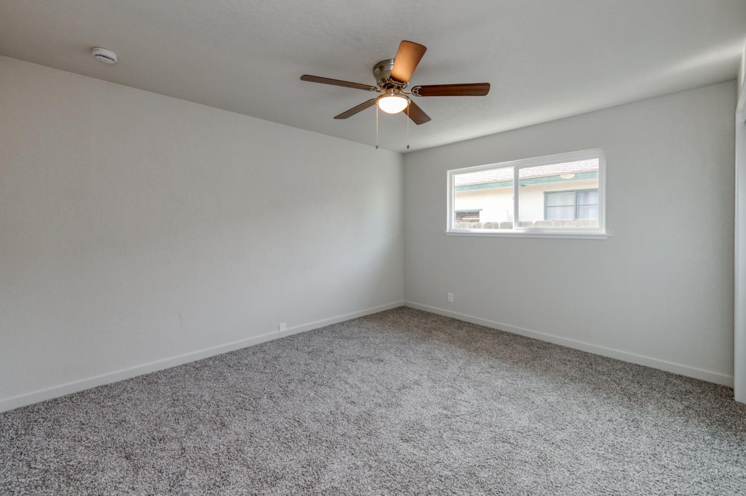 4031 East Pontiac Way Fresno, CA 93726 - Photo 23 of 46 an empty room with a window and a fan