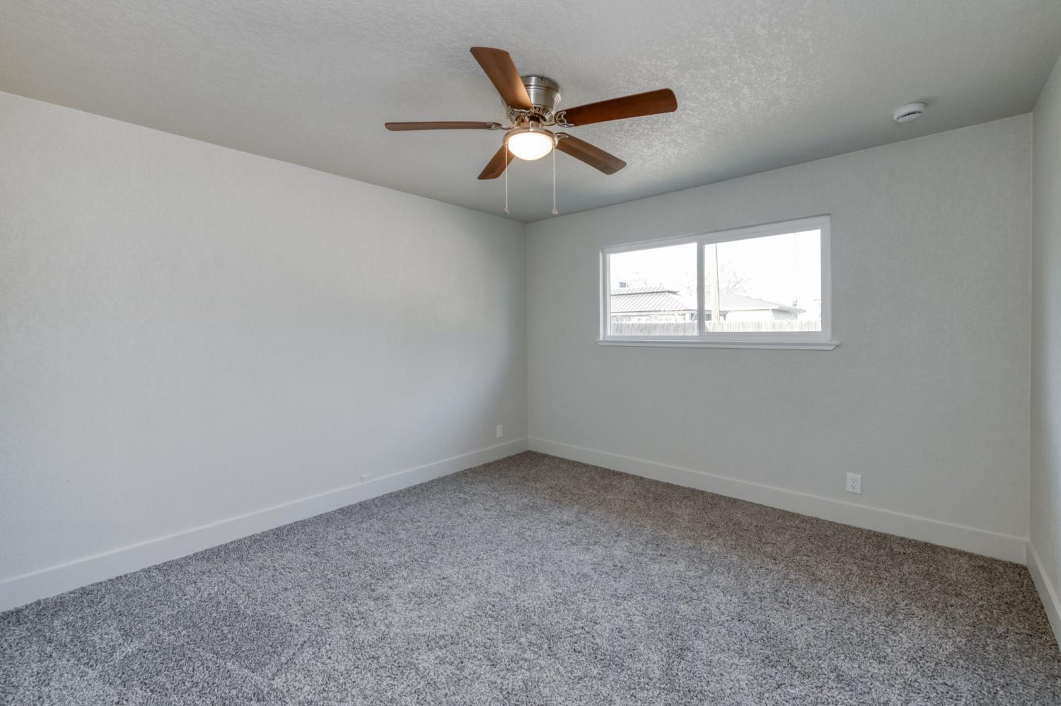 4031 East Pontiac Way Fresno, CA 93726 - Photo 25 of 46 an empty room with windows and ceiling fan