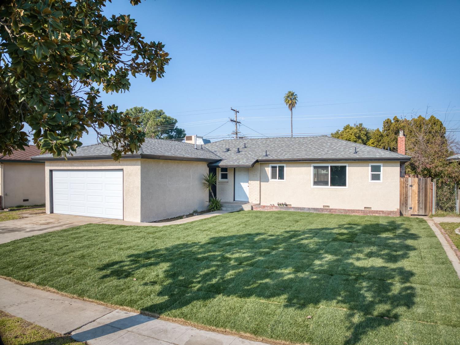 4031 East Pontiac Way Fresno, CA 93726 - Photo 36 of 46 a view of a yard in front of a house with plants and large tree