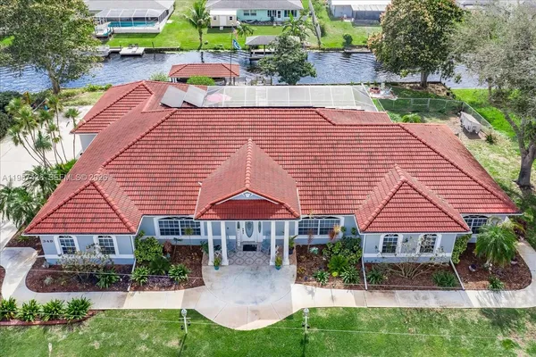 an aerial view of a house with yard and a patio