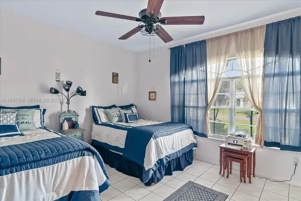 a bedroom with a large bed and a chandelier fan