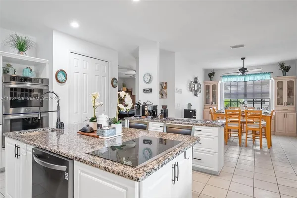 a kitchen with stainless steel appliances granite countertop a sink and a refrigerator