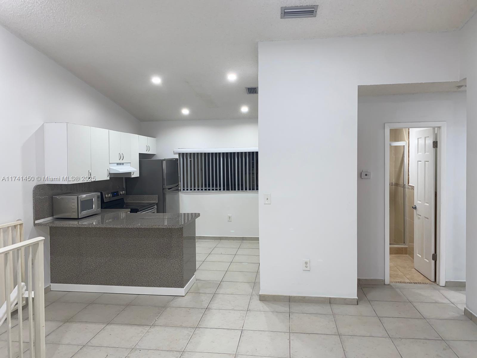 7775 West 29th Way, Unit 201 Hialeah, FL 33018 - Photo 5 of 14 a large kitchen with cabinets and stainless steel appliances