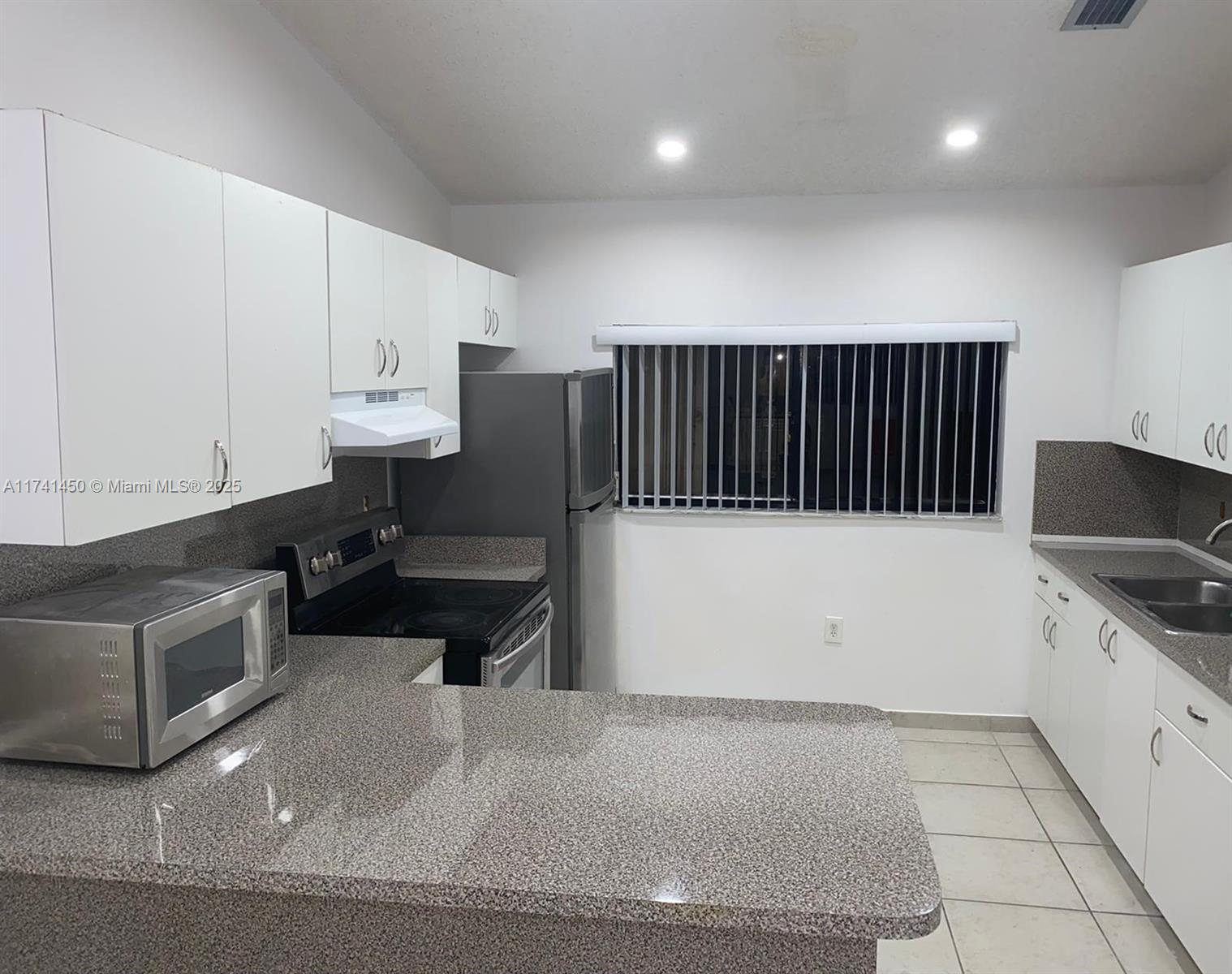7775 West 29th Way, Unit 201 Hialeah, FL 33018 - Photo 6 of 14 a kitchen with a cabinets and white appliances