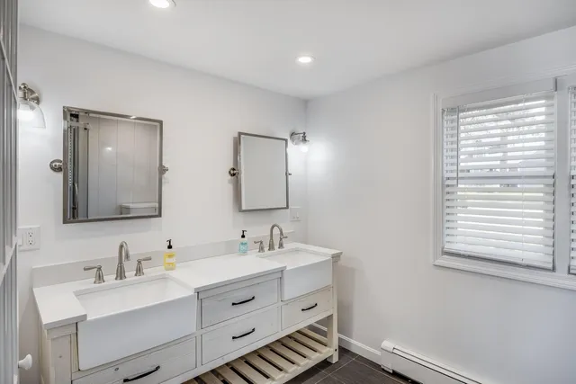 a bathroom with a double vanity sink mirror double and shower