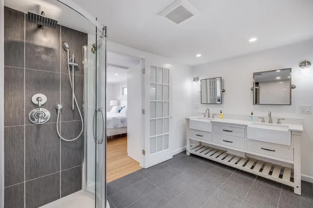 a bedroom with a bed and a lamp on dresser