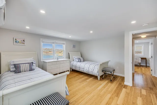 a view of an empty room with wooden floor and closet area