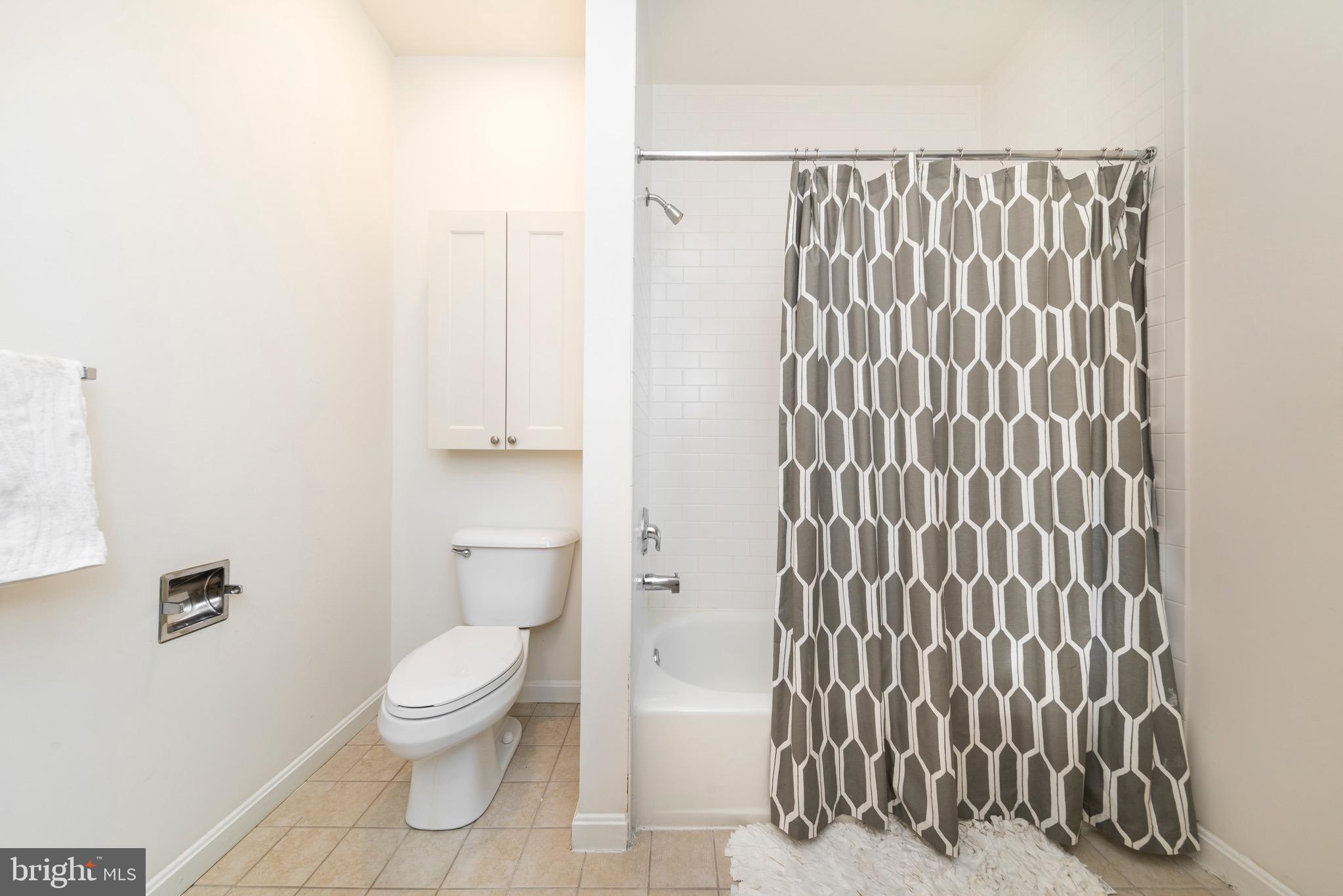 101 Wells Baltimore Md 21230, Unit 2BR Baltimore, MD 21230 - Photo 46 of 46 a white toilet sitting next to a shower curtain