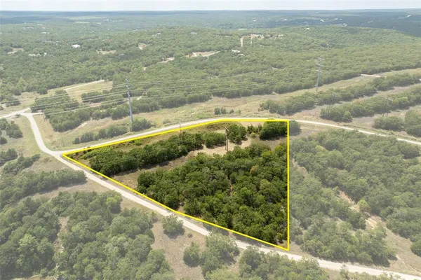 an aerial view of residential houses with outdoor space and trees