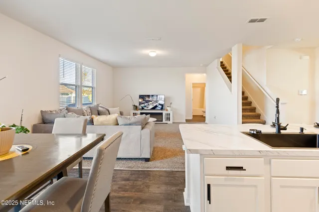 a living room with furniture a large window and kitchen view