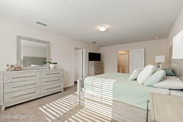 a bedroom with a bed and a large mirror