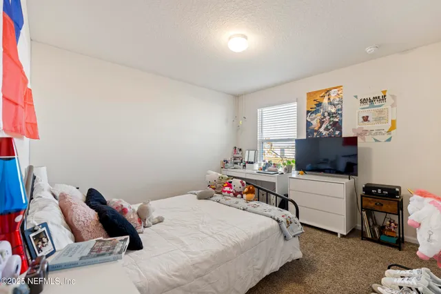 a bedroom with a bed and a tv