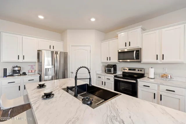 a kitchen with stainless steel appliances a stove a sink a refrigerator and cabinets