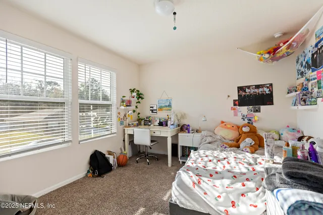 a room with furniture a rug toys and windows