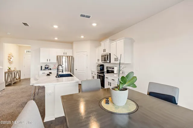 a kitchen with a table and a potted plant