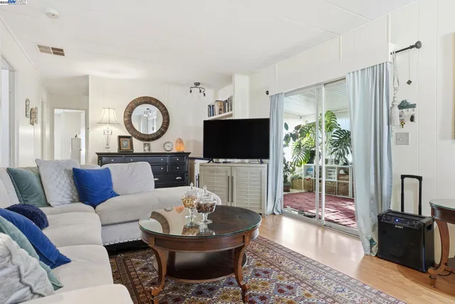 a living room with furniture a flat screen tv and a view of kitchen