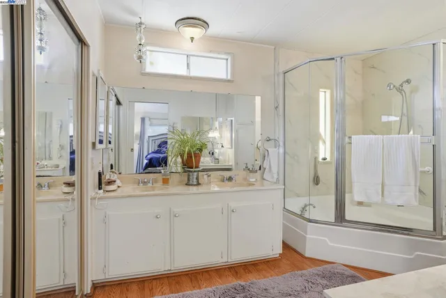 a bathroom with a double vanity sink mirror and shower